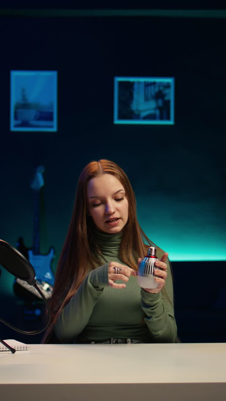 Young Woman Demonstrating Smart Light Bulb in Home Studio