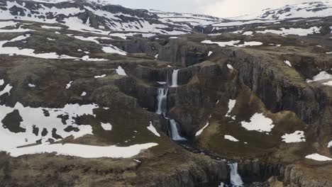cascadas de clifbrekkufossar que descienden por las colinas durante un día de invierno nevado