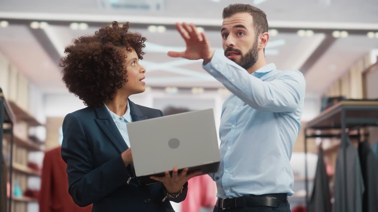 Clothing Store: Businesswoman Uses Tablet Computer, Talks to Visual Merchandising Specialist, Collaborate To Create Stylish Collection. Small Business Fashion Shop Sales Manager Talks to Designer.