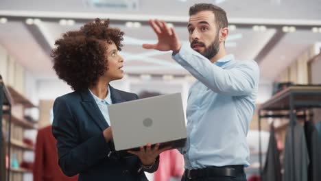 clothing store: businesswoman uses tablet computer, talks to visual merchandising specialist, collaborate to create stylish collection. small business fashion shop sales manager talks to designer.