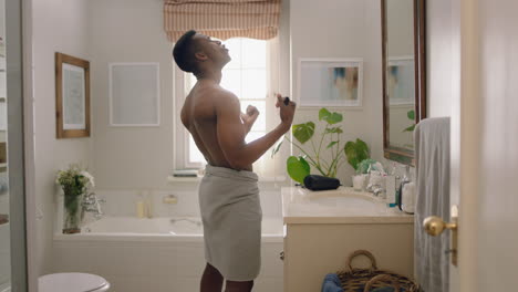 hombre afroamericano feliz bailando sin camisa en el baño mirándose en el espejo divirtiéndose rutina matutina preparándose disfrutando de una imagen positiva de sí mismo haciendo bailes tontos celebrando el éxito