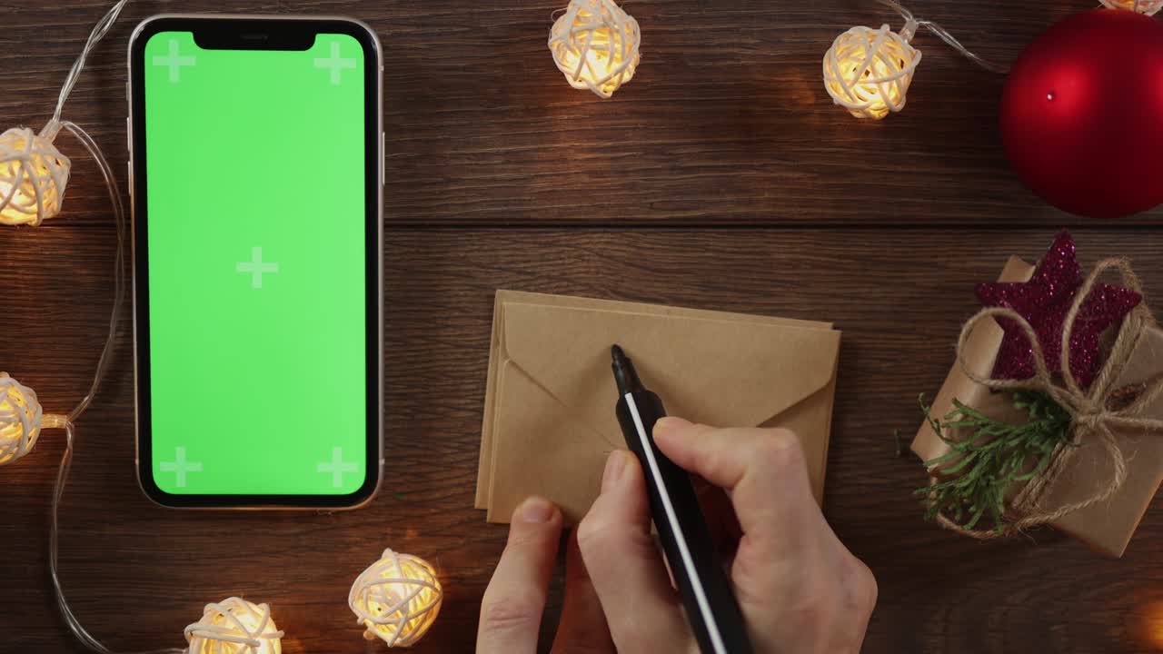 winter holidays present box and smartphone green screen on wooden desk garland