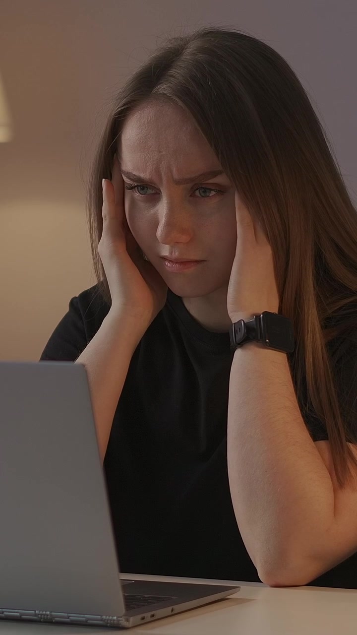 Giovane donna con mal di testa e stress mentre lavora al laptop