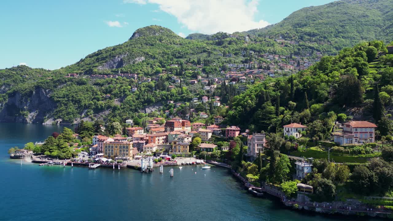 Drone hovers from afar, slowly rotating to reveal Varenna’s harbor and tourists by the lake
