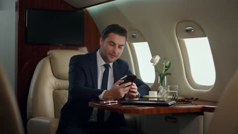 busy man finishing phone call in luxury jet. focused manager drinking coffee