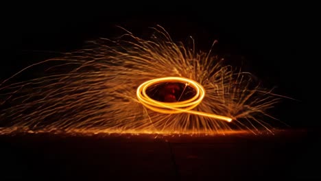 captivating display of fire spinning: a stunning showcase of light trails and sparks captured in dynamic motion during a mesmerizing nighttime performance