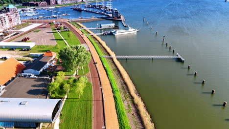 Moving along the waterfront of the Markermmer lake, Lelystad,the Netherlands. Yachts and boats at the berth at backdrop. Aerial view.