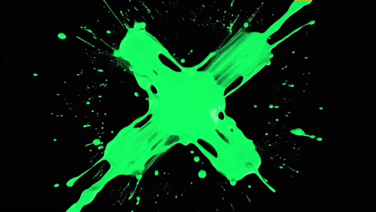 Vernice verde che schizza formando una X su sfondo nero