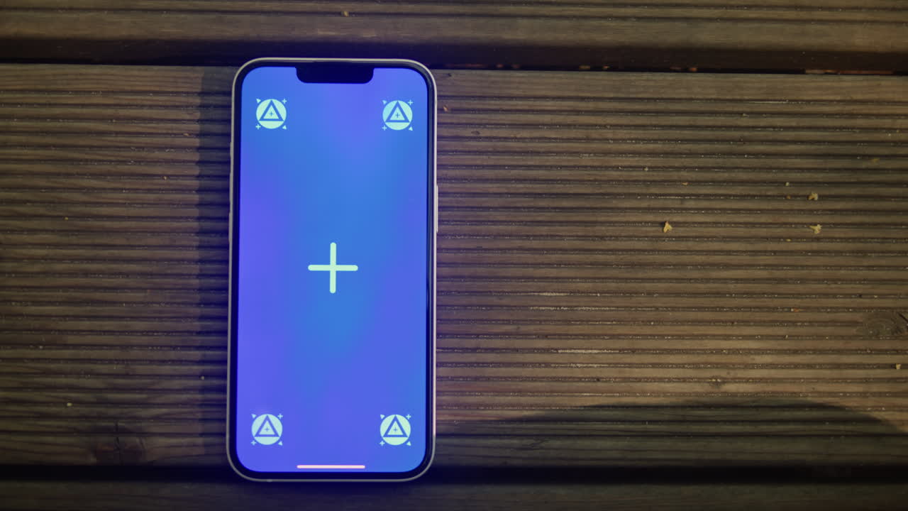 Phone with chroma key screen on the wooden background close-up. Green screen on smart phone. Nature