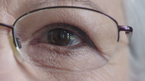cerrar el ojo de una mujer mayor que se abre mirando a la cámara con gafas