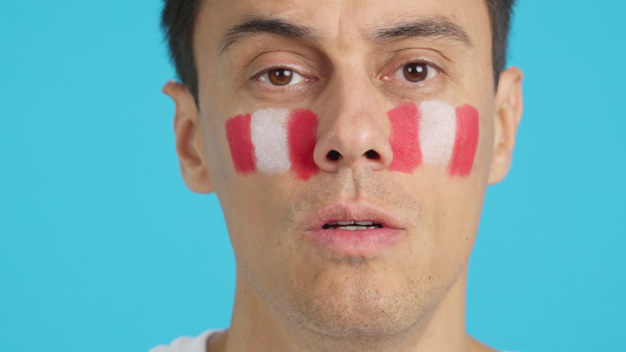 Man with a peruvian flag painted on the face smiling