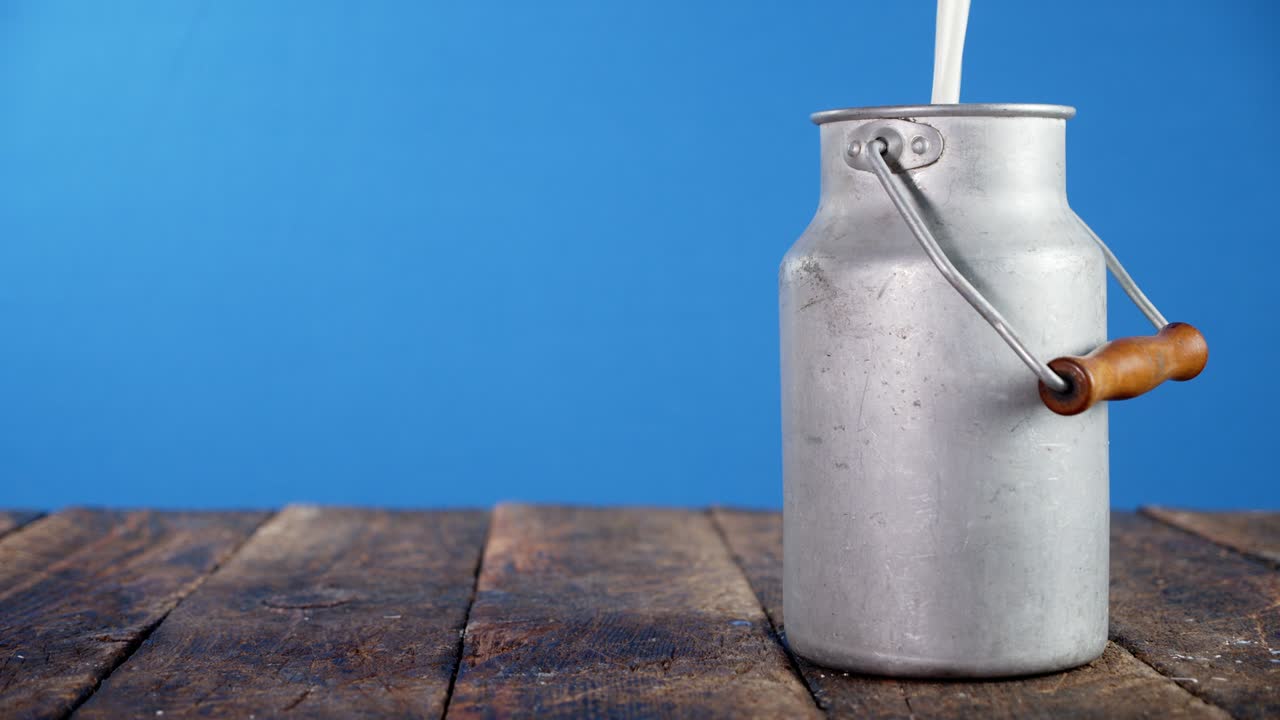 leite a ser derramado numa lata na mesa.