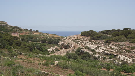 paisaje rural de 4k con una antigua muralla y el mar mediterráneo a lo lejos en la isla de malta durante un caluroso día de verano