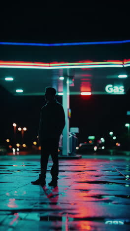 silhouette at a night gas station