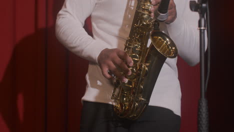 close up view of latin man playing sax during live music perfomance