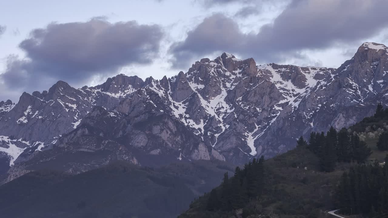 cresta de montaña con árboles bajo un cielo nublado