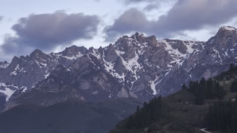 Mountain-ridge-with-trees-under-cloudy-sky