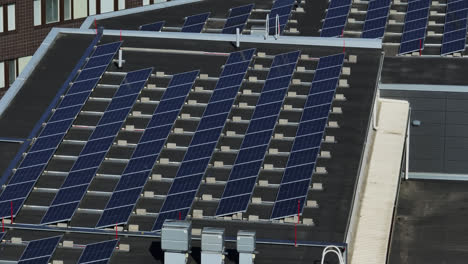 telephoto drone shot around solar panels on a building roof, on a summer day