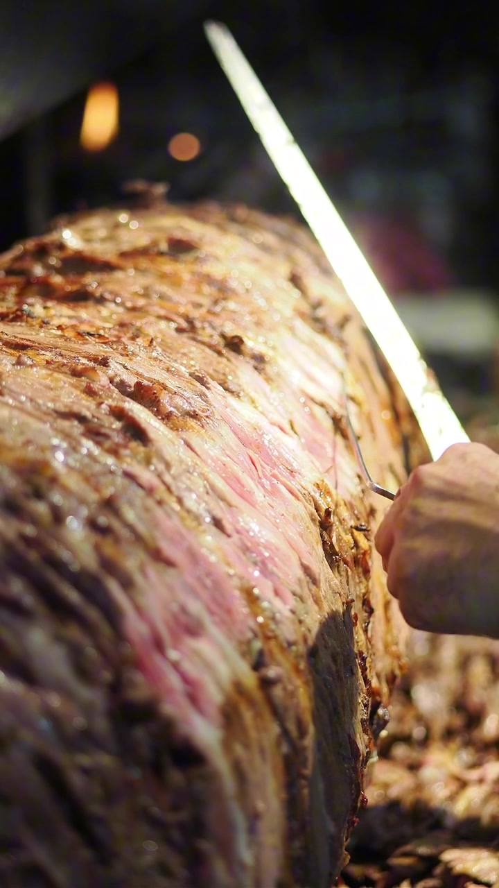 Chef che affetta carne di doner kebab tradizionale.