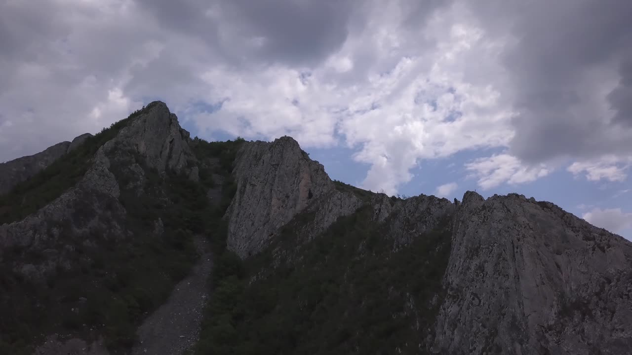 Aerial View Of Backpacker Alpinist On Summit Of Rocky Mountain In Nature