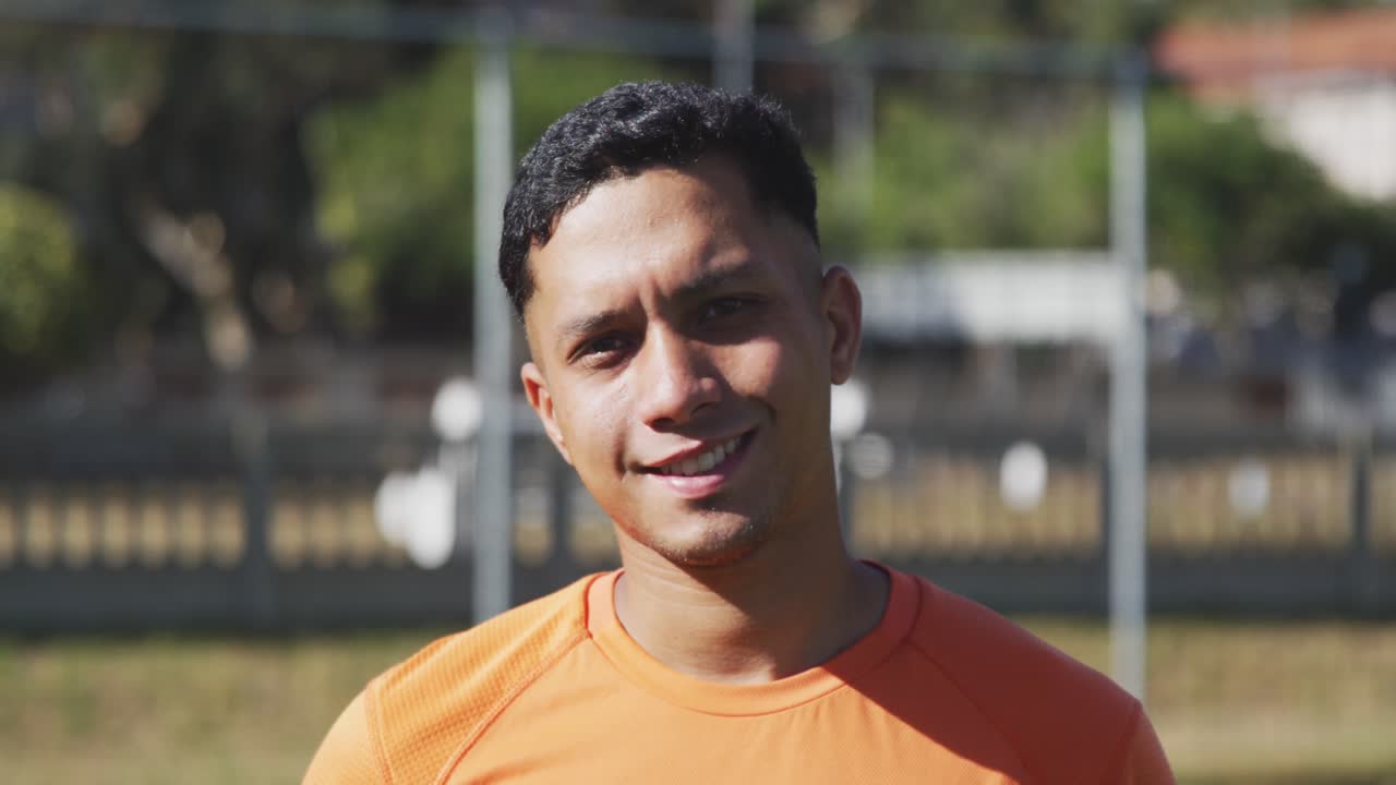Fotbalista usmívající se do kamery na hřišti