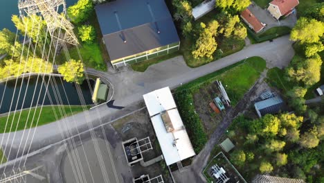 Top-down-aerial-of-small-island-surrounded-by-river-water-and-electrical-wires