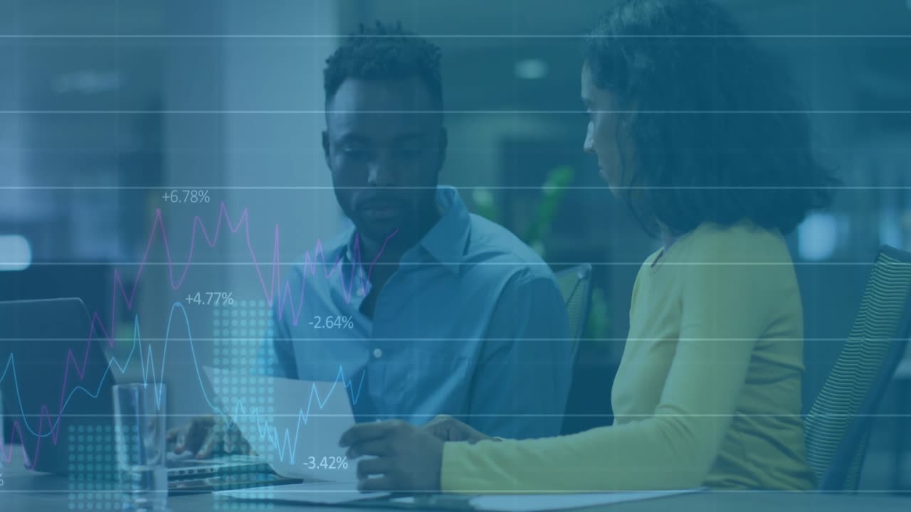 woman pointing to document initiating data overlays while colleague reviewing finance charts