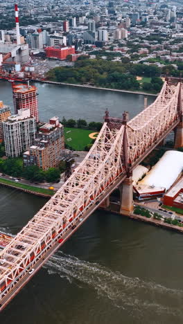 gorgeous structure of queensboro bridge over east river. yachts, boats and ferries float under the bridge. top view.