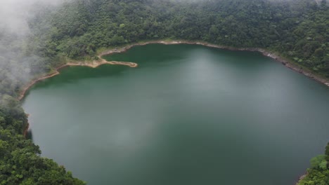 Beautiful-View-Of-Danao-Lake-Surrounded-By-Forested-Landscape-On-A-Foggy-Morning-In-San-Juan,-Southern-Leyte,-Philippines---Aerial-Shot