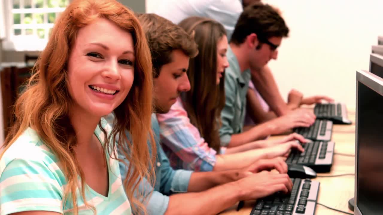 Happy student smiling at camera in computer class