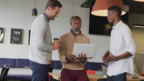 Happy-diverse-business-people-discussing-work-during-meeting-at-office