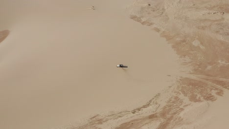 antena: un camión con kitesurfistas viajando a través de las dunas de lencois maranhenses en brasil, durante la estación seca