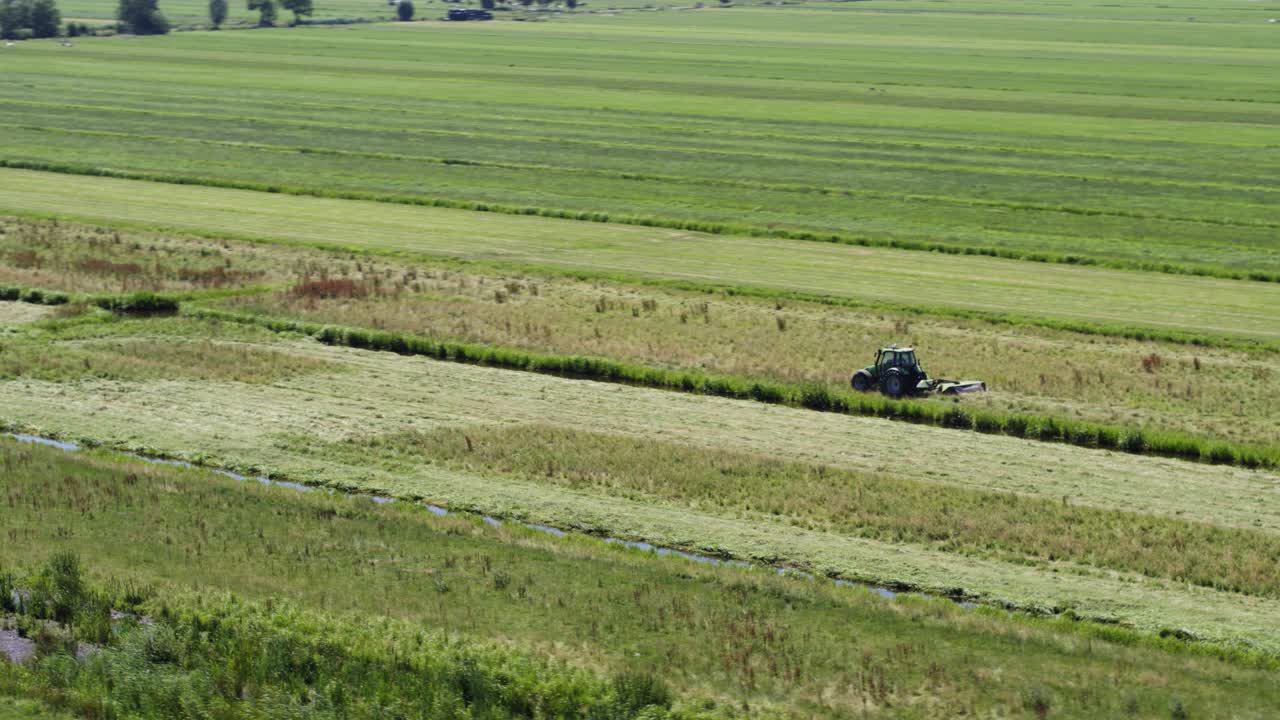 끝없는 녹색 활기찬 농지 필드, 공중 궤도 보기에서 작동 하는 외로운 트랙터