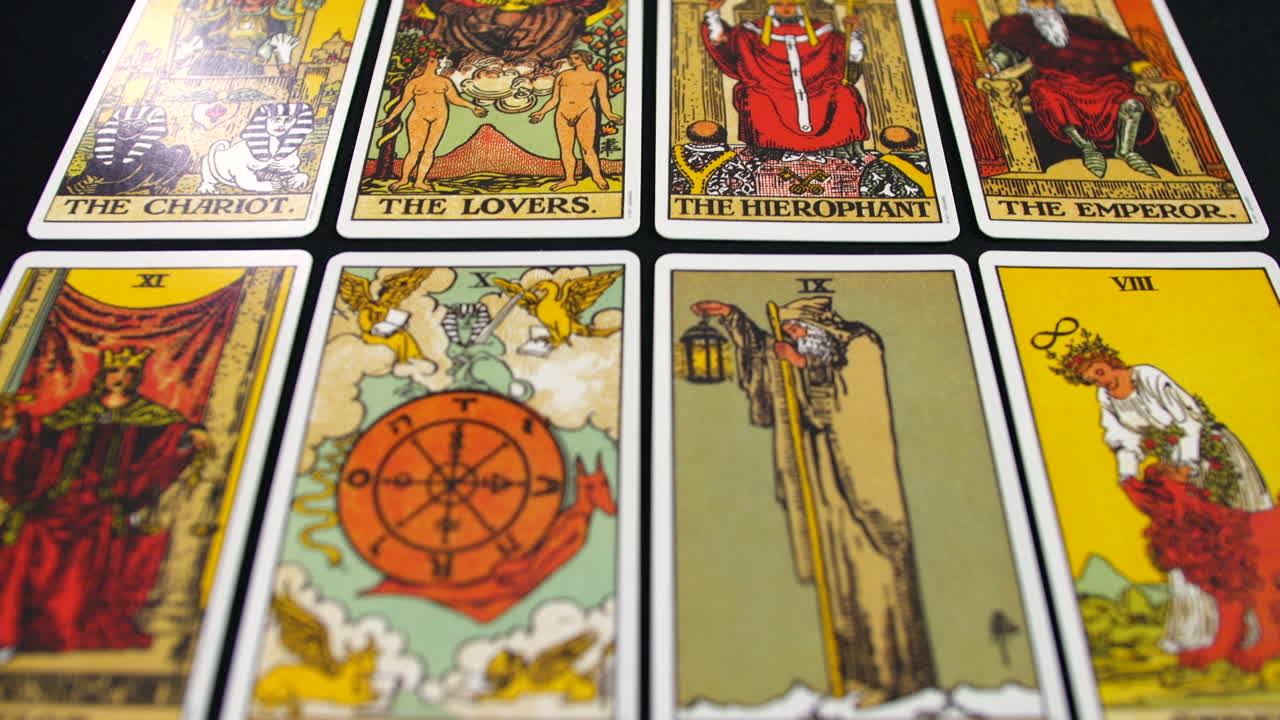 las cartas del tarot se extienden a través de una superficie, mostrando las principales ilustraciones arcanas en detalles vibrantes. la vista de arriba hacia abajo destaca obras de arte intrincadas y diseños simbólicos en la cubierta