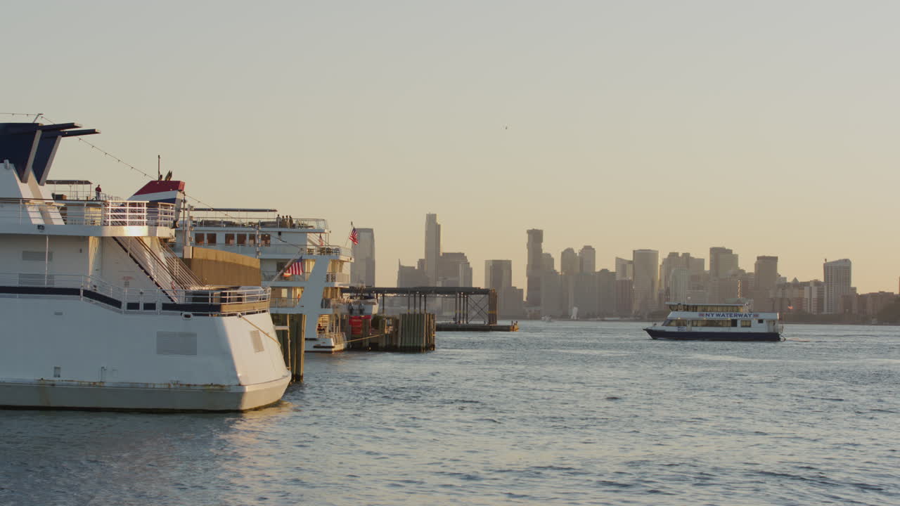 New York Waterway Ferry In The Distance Crossing The Hudson And Coming Into Harbour Pier During Golden Hour. Slow Motion, Locked Off