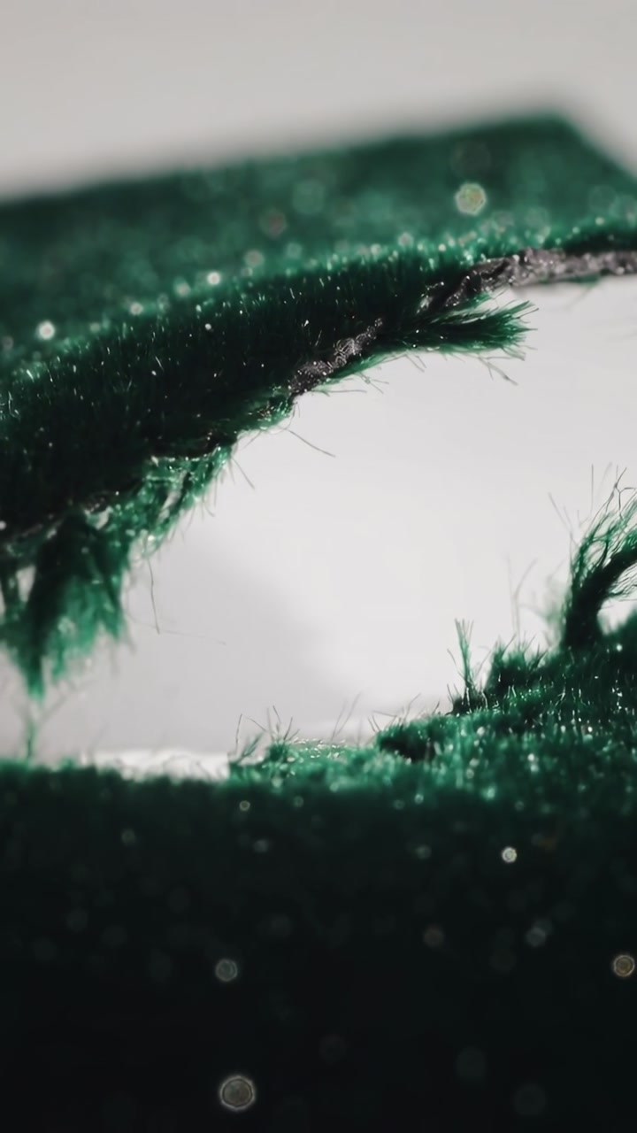 Macro Close-Up of Dark Green Velvet Fabric with a Tear