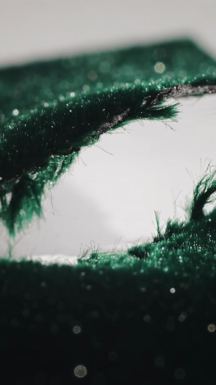 Macro Close-Up of Dark Green Velvet Fabric with a Tear