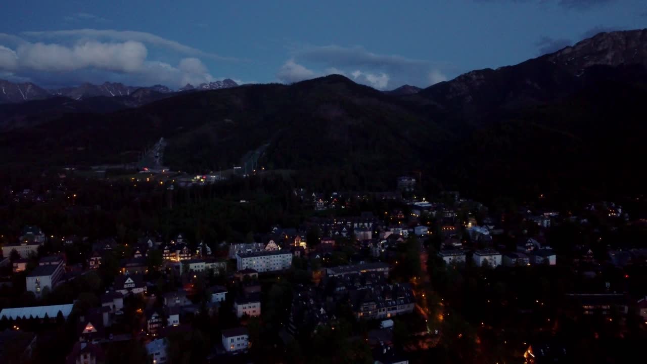 Stunning night time flyover of Zakopane, Poland, a resort town against the Tatra Mountains, and its stunning Goral traditional architecture