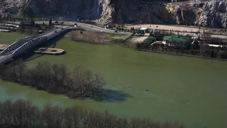 Muddy-water-of-Buna-river-and-bridge-after-flooding-rain-in-Shkoder,-Albania