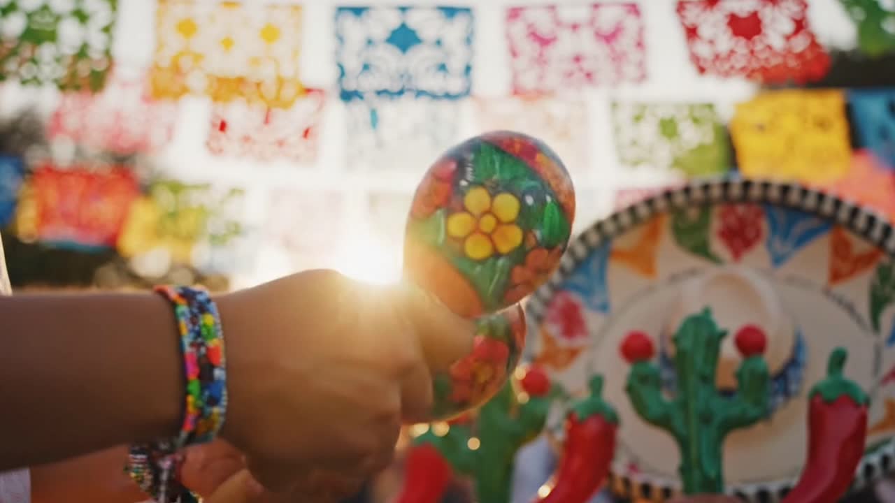 Hånd ryster farverig maraca under traditionel mexicansk fiesta.