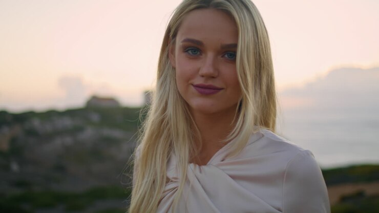 modèle blond reposant soir chateau portrait. fille détendue touchant les cheveux coucher du soleil