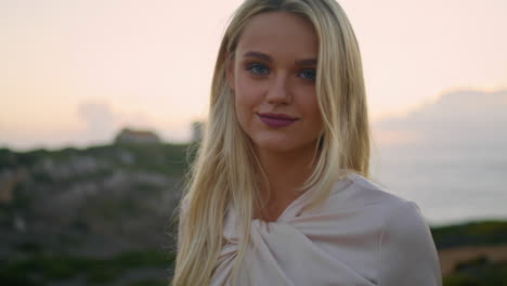 blonde model resting evening chateau portrait. relaxed girl touching hair sunset