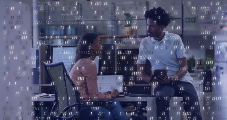 woman typing laptop and man holding tablet discussing tech in office, with floating binary digits