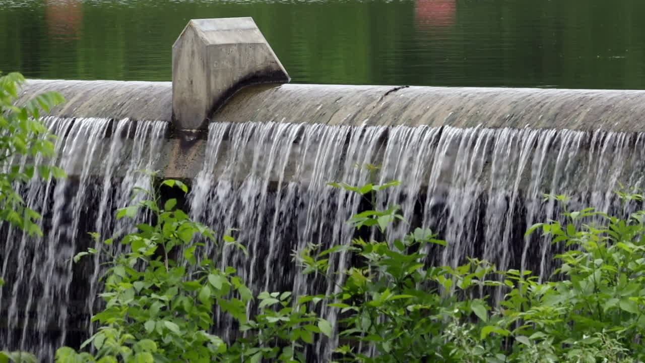 Some water flowing over a dam out from a reservoir
