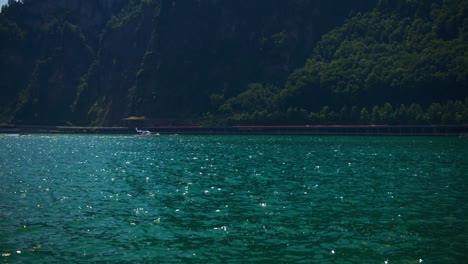 Vista-Tranquila-De-La-Lancha-Rápida-Que-Se-Dirige-Al-Muelle-En-El-Lago-De-La-Montaña---Montañas-Suizas-Hergiswil-En-4k