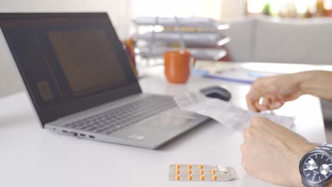 the patient, checking the package insert on his laptop, looks at the drugs.