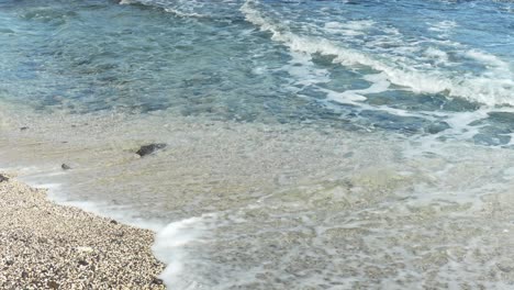 ocean waves flowing over beach with tiny rocks in tenerife