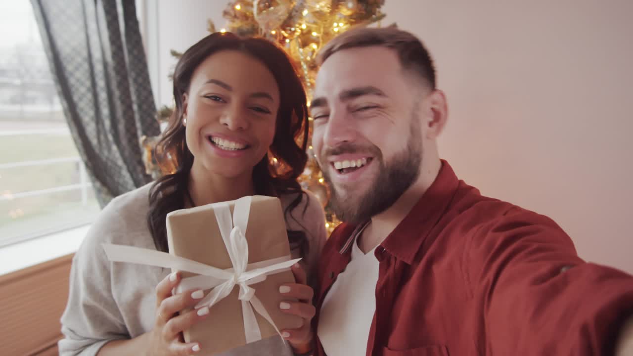 una pareja feliz hablando con amigos en una llamada de video en navidad.