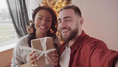 um casal feliz a conversar com amigos por videoconferência no natal.