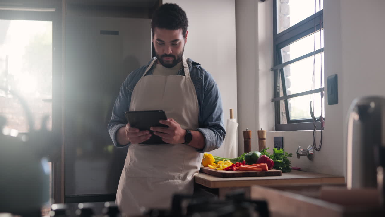 hombre usando tableta para preparar comida en la cocina